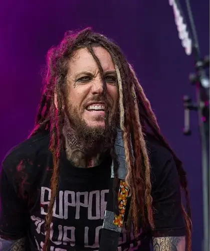 Guitarrista do 'Korn' compartilhou nas redes sociais um momento marcante de sua vida familiar: o batismo de sua mãe aos 83 anos. Foto: Reprodução/Wikimedia Commons/Sven Mandel/Instagram/Brian Welch