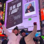 Casal revela capa do livro de estreia, "Eis-me aqui e agora?'', nos letreiros luminosos da Times Square, em Nova York. Foto: Arquivo Pessoal.