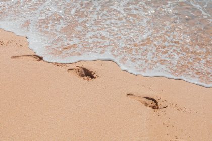 Fotos com Pegadas na Areia e a água do mar quase encobrindo